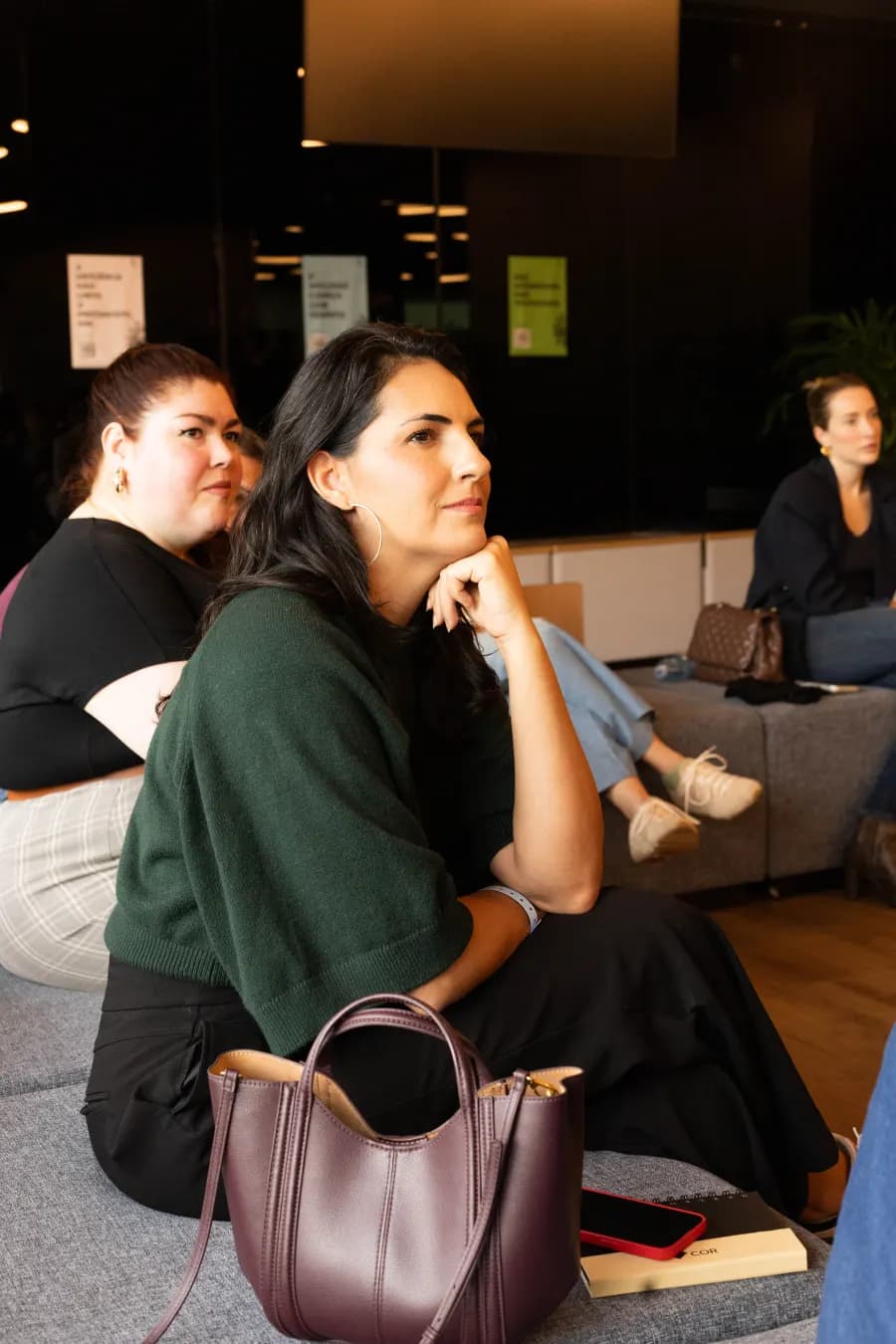 Participantes acompanhando a conversa sentados no chão
